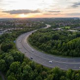 The Outer Ring Road curving through open green land at dusk